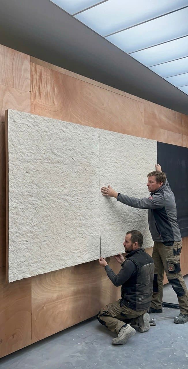 Detailná inštalácia ohybného kameňa AT-Europe na zaoblenú stenu pomocou flexibilného lepidla, demonštrujúca ľahkú manipuláciu a prispôsobivosť materiálu.